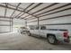 Interior of a garage with two silver pickup trucks parked inside at 38820 N 10Th St, Phoenix, AZ 85086