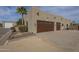 Oversized three-car garage provides ample parking and storage, set against a backdrop of desert landscaping and blue skies at 38820 N 10Th St, Phoenix, AZ 85086