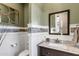 Charming powder room featuring a decorative mirror, granite countertops, and wainscoting at 3930 E Enrose St, Mesa, AZ 85205