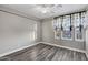 An empty bedroom with wood floors, white trim, and a sheer black and white curtain at 3930 E Enrose St, Mesa, AZ 85205