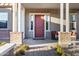Inviting front porch with brick accents, cozy seating, and a stylish red door at 3930 E Enrose St, Mesa, AZ 85205