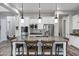 Modern kitchen with white cabinets, granite countertops, stainless steel appliances, and three pendant lights at 3930 E Enrose St, Mesa, AZ 85205