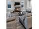 Cozy living room with a stone fireplace, large TV, and comfortable leather sofas, perfect for relaxing and entertaining at 3930 E Enrose St, Mesa, AZ 85205