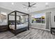 The main bedroom boasts a dark wood four poster bed, neutral walls, and abundant natural light from large windows at 3930 E Enrose St, Mesa, AZ 85205