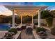 Cozy outdoor dining under a pergola, next to a refreshing swimming pool at 3930 E Enrose St, Mesa, AZ 85205