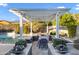 Backyard pergola with a table, chairs and flower pots overlooking a pool at 3930 E Enrose St, Mesa, AZ 85205