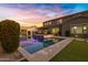 Twilight view of a luxurious pool and spa, set amidst a beautifully lit backyard at 3930 E Enrose St, Mesa, AZ 85205