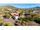 A stunning aerial view of a sprawling desert home featuring a terracotta roof and a refreshing pool, set amidst scenic hills at 44434 N 20Th St, New River, AZ 85087