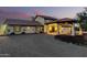 Southwestern home at twilight featuring a porte cochere, three-car garage, and tiled roof at 44434 N 20Th St, New River, AZ 85087
