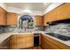 Kitchen features natural wood cabinetry, mosaic tile backsplash, stainless steel appliances, and a garden window at 44434 N 20Th St, New River, AZ 85087
