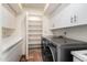Well-lit laundry room with modern appliances, storage, and tile floors at 44434 N 20Th St, New River, AZ 85087