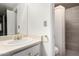 Bathroom featuring a sink with gold fixtures, a mirror, and a tiled shower at 4444 E Paradise Village N Pkwy # 132, Phoenix, AZ 85032