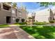 Exterior view of condo buildings with well-maintained landscaping and a bench at 4444 E Paradise Village N Pkwy # 132, Phoenix, AZ 85032
