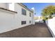 A view of the backyard, illustrating the spacious gravel area, and the home's white exterior at 4748 E Redfield Rd, Phoenix, AZ 85032