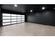 Spacious garage with a modern black ceiling and a transparent glass garage door at 4748 E Redfield Rd, Phoenix, AZ 85032
