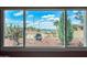Window view showcasing desert landscape, featuring mature trees, cactus, and scenic mountain backdrop at 508 N Sierra Vista Dr, Wickenburg, AZ 85390