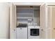 A laundry closet with a washer, dryer and built in shelves at 7327 E Via Estrella Ave, Scottsdale, AZ 85258