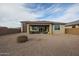 Wide angle shot of the home's rockscaped backyard with covered patio and sliding glass doors at 7735 W Agora Ln, Phoenix, AZ 85043