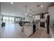 Open-concept kitchen featuring white cabinets, black appliances, and an eat-in island at 7735 W Agora Ln, Phoenix, AZ 85043