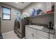 Convenient laundry room with modern washer and dryer, sink, and storage at 7735 W Agora Ln, Phoenix, AZ 85043