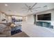 Open-concept living space with sleek tile flooring, ceiling fan, and connection to the kitchen area at 7735 W Agora Ln, Phoenix, AZ 85043