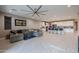 Open-concept living room with tile floors, a ceiling fan and connecting kitchen and bar stool seating at 7735 W Agora Ln, Phoenix, AZ 85043
