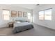 Bright bedroom with neutral walls, carpet, and a serene gray-blue bed set beneath modern artwork at 8804 W Vista Ave, Glendale, AZ 85305