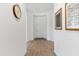 Bright hallway with wood floors and arched doorway leading to a white front door and decorative wall art at 8804 W Vista Ave, Glendale, AZ 85305