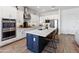 Contemporary kitchen with white cabinets, stainless steel appliances, and a navy blue kitchen island at 8804 W Vista Ave, Glendale, AZ 85305