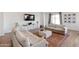 Spacious living room with neutral-toned sofas, wood floors, decorative rug, and a large television at 8804 W Vista Ave, Glendale, AZ 85305