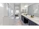 Bright main bathroom with marble floors, dual sink vanity, glass shower, and neutral walls at 8804 W Vista Ave, Glendale, AZ 85305