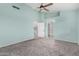 Bedroom with blue walls features a ceiling fan, carpet, and entry into the hall at 939 W Azalea Pl, Chandler, AZ 85248