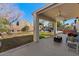 Inviting back patio featuring a covered area with ceiling fans and well maintained desert landscaping at 9826 E Irwin Cir, Mesa, AZ 85209