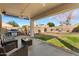 An outdoor covered patio featuring a BBQ grill, patio furniture, and lush green grass at 9826 E Irwin Cir, Mesa, AZ 85209