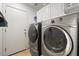 A clean and organized laundry room with front-load washer and dryer and ample cabinet storage at 9826 E Irwin Cir, Mesa, AZ 85209