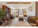Well-lit living room featuring neutral tones, beamed ceilings, and access to the front porch at 9826 E Irwin Cir, Mesa, AZ 85209