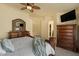 Spacious main bedroom features a large bed, wooden dresser, carpeted floors, and a ceiling fan at 9826 E Irwin Cir, Mesa, AZ 85209