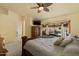 Spacious main bedroom features a large bed, wooden dresser, carpeted floors, ceiling fan and backyard view at 9826 E Irwin Cir, Mesa, AZ 85209