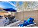 Inviting outdoor patio area with ample seating, a blue umbrella, and a built-in grill at 10203 N 12Th Pl # 3, Phoenix, AZ 85020