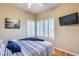 Cozy bedroom with shuttered windows, a wall-mounted television, and a comfortable bed with blue accents at 10203 N 12Th Pl # 3, Phoenix, AZ 85020