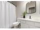 Neutral colored bathroom featuring a white shower curtain, sink, vanity, and toilet at 10318 E Irwin Ave, Mesa, AZ 85209