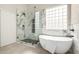 Modern bathroom featuring a glass shower, freestanding tub, and marble walls at 10318 E Irwin Ave, Mesa, AZ 85209