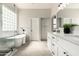 Bright bathroom featuring a soaking tub, double sink vanity, marble-style wall and floor tiles, and glass enclosed shower at 10318 E Irwin Ave, Mesa, AZ 85209