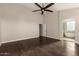 Spacious main bedroom with dark hardwood floors, fan and ensuite bathroom with soaking tub at 10318 E Irwin Ave, Mesa, AZ 85209