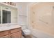 Bathroom featuring a vanity, mirror, toilet and a shower over bath with grab rails at 10419 W Loma Blanca Dr, Sun City, AZ 85351
