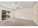 Bright bedroom featuring neutral carpet, ceiling fan, sliding glass door and built in cabinet storage at 10419 W Loma Blanca Dr, Sun City, AZ 85351