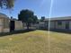 Expansive backyard features lush green grass and mature trees and an outbuilding at 10633 N 46Th Ave, Glendale, AZ 85304