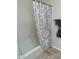 Bathroom tub and shower with decorative shower curtain at 10633 N 46Th Ave, Glendale, AZ 85304