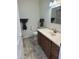 Bright bathroom featuring tile flooring, wood cabinet, and modern fixtures at 10633 N 46Th Ave, Glendale, AZ 85304