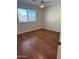 Empty bedroom with wood floor, a large window, and white walls at 10633 N 46Th Ave, Glendale, AZ 85304
